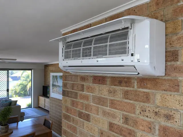 Open split system indoor unit with clean filters on a brick wall in a bright living room in Palm Beach